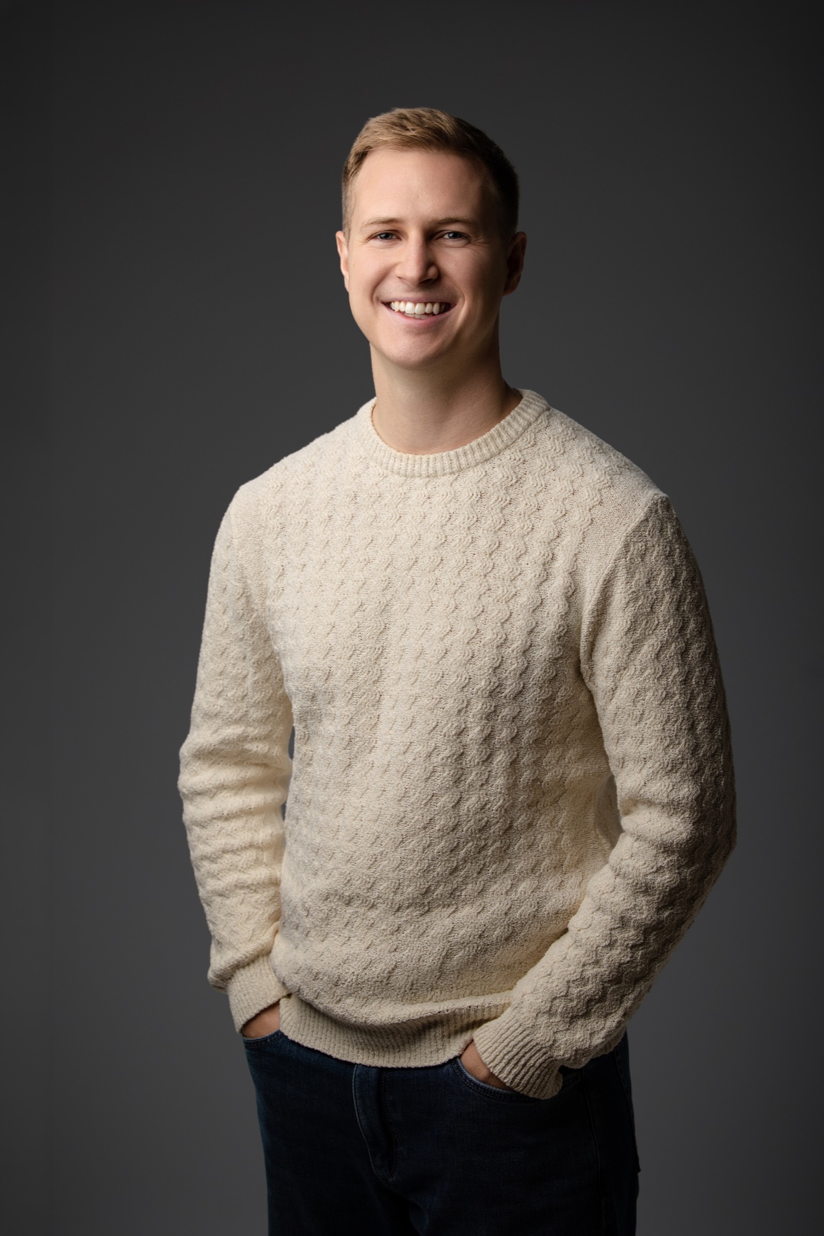 Bo Farley smiling in a cream sweater